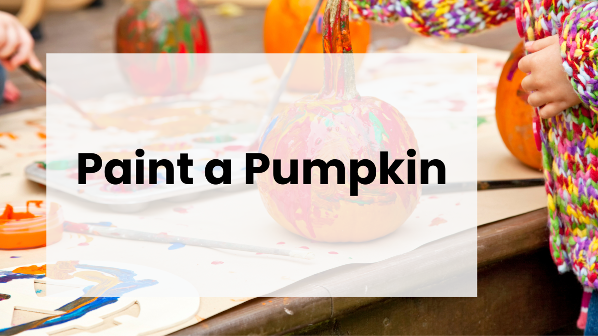 Child's hand holding a painted pumpkin